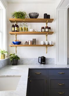 the shelves in this kitchen are filled with bottles and cups