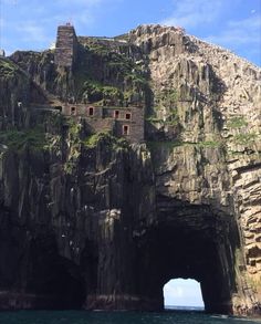 a large rock formation on the side of a body of water next to a cliff