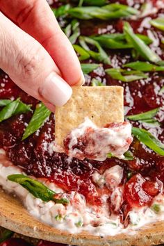 a person dipping a cracker into a pizza