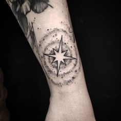 a black and white photo of a person's arm with a star tattoo on it