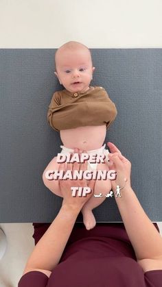 a woman holding a baby in her arms with the words diaper changing tips on it