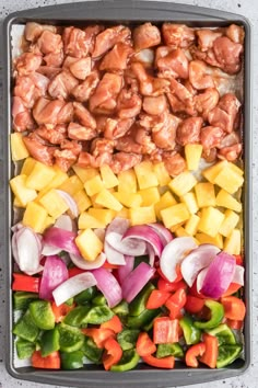 chicken, peppers, and pineapples in a pan ready to be cooked together