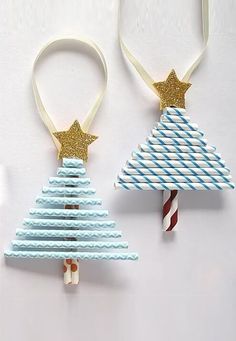 two paper christmas trees with gold stars on top and candy canes in the bottom