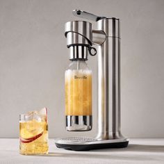 a beverage dispenser with a glass next to it