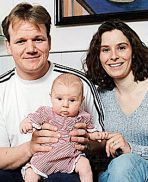 a man and woman sitting next to each other holding a baby