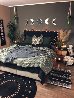 a bed room with a neatly made bed and several hanging moon phases on the wall