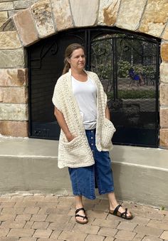 a woman standing in front of a stone fireplace