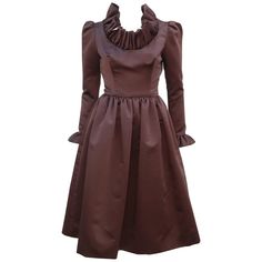 Jill Richards, the California designer of this fabulous 1970's cocktail dress, had the well earned nickname of 'Ruffles Richards' with both a flair for drama and flattering silhouettes. The dress is fabricated from a rich chocolate brown satin fabric which is expertly cut to provide a fitted torso yielding to a voluminous skirt featuring hidden side pockets (love a hidden pockets in cocktail wear!). The lovely sleeves provide a gentle pouff at the shoulder with a skinny fit to the ruffled cuff. Elegant A-line Midi Dress For Vintage Fashion, Party Vintage A-line Dress With Ruffles, Elegant Knee-length Midi Dress In Vintage Style, Retro Ruffled Dresses For Fall, Chic Vintage Dress With Ruffles For Formal Occasions, Chic Vintage Ruffled Dress For Formal Occasions, Fall Evening Midi Dress With Ruffles, Chic Formal Vintage Dress With Ruffles, Chic Vintage Evening Dress For Fall