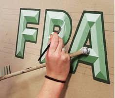 a person is painting letters on the wall