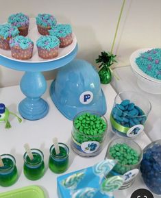 a table topped with blue and green cupcakes