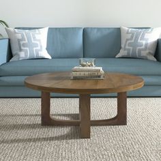 a living room with a blue couch and two books on the coffee table in front of it