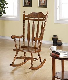 a wooden rocking chair sitting on top of a hard wood floor next to a window