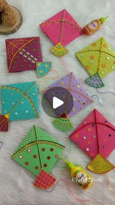 several colorful kites sitting on top of a white furnishing next to doughnuts