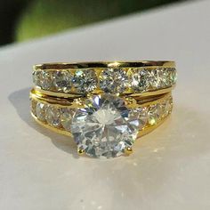 a couple of rings that are sitting on top of a white surface with some diamonds in them