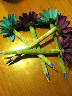 purple and green flowers are arranged in the shape of a triangle on a wooden table