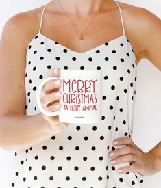 a woman is holding a coffee mug in one hand and wearing a polka dot dress