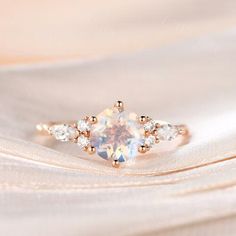 a white diamond ring sitting on top of a cloth