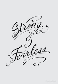 the words strong and fearless written in cursive writing on a gray background with black ink