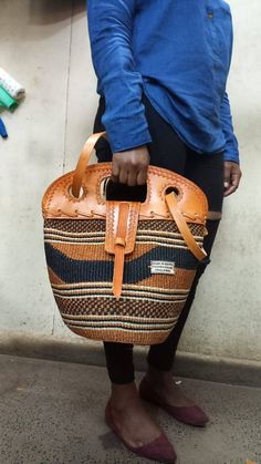 "Brown and black sisal tote bag with leather flap DIMENSIONS Bottom width: 10\" Top width: 14\" Depth: 10\" Straps: 15\" SHIPPING All orders ship via DHL Express (3-5) days delivery time." Casual Handwoven Leather Bag, Leather Bucket Straw Bag For Market, Handwoven Bucket Tote Bag For Daily Use, Handwoven Leather Bucket Bag With Double Handle, Market Tote Shoulder Bag With Leather Handles, Handwoven Leather Double Handle Bucket Bag, Tote Shoulder Bag With Leather Handles For Market, Leather Handle Tote Shoulder Bag For Market, Eco-friendly Leather Shopping Shoulder Bag