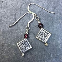 Dark red Garnet gemstone earrings with Celtic knot work beads See the coins for scale. Small - Approximately 1.1 inch. 2.5 cm. See the coins for scale. Sterling silver earwires.  Sold in an organza bag with designer tags. Please look at more Connemara marble and gemstone jewelry in my shop https://www.etsy.com/ie/shop/IrishJewelleryGifts. Garnet is reputed to be the stone for success socially and in business. We love it because it compliments the Connemara in such a subtle way. It reminds us of Nickel-free Sterling Silver Round Bead Jewelry, Nickel-free Sterling Silver Jewelry With Round Beads, Nickel-free Round Bead Earrings As Gift, Nickel-free Beaded Earrings As Gift, Nickel-free Beaded Earrings For Gifts, Jewelry With Matching Round Bead Earrings For Gifts, Jewelry With Matching Round Beaded Earrings For Gifts, Jewelry Set With Matching Round Bead Earrings For Gifts, Symbolic Silver Jewelry With Round Beads