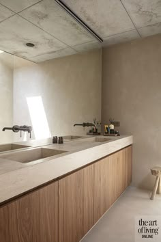 a kitchen counter with two sinks and a window in the backround behind it