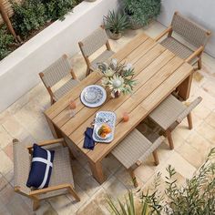 an overhead view of a table and chairs with food on the plate, next to potted plants