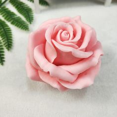 a pink rose sitting on top of a white table