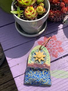 a potted plant sitting on top of a wooden table next to a flower pot