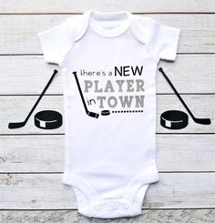 Theres A New Player In Town Hockey Bodysuit, Hockey Baby Outfit, Hockey Fan, Hockey Dad, Baby Sports Hockey Puck Gender Reveal, White Sporty Onesie For Sports, White Cotton Sports Bodysuit, Sporty Onesie With Letter Print For Sports, White Cotton Sporty Bodysuit, Hockey Baby Announcement, Sporty White Cotton Bodysuit, Hockey Pregnancy Announcement, Hockey Grandma