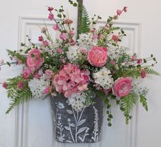 a vase filled with pink and white flowers sitting on top of a door sill