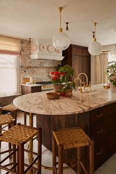 a large kitchen with marble counter tops and wooden stools