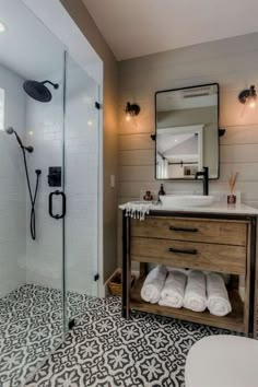 a bathroom with a sink, mirror and shower stall