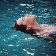 a woman floating on top of a body of water