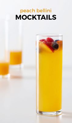 two glasses filled with orange juice and raspberries