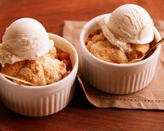 two desserts with ice cream in small white dishes on top of a tablecloth