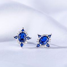 Straightforward in design and unmatched in color, these striking sapphire stud earrings are ideal for everyday wear. Created in sterling silver, each earring features a oval cut stone sparking at its center, while additional blue pear-cut stones line the glittering halos for extra shimmer. An imaginative look you'll adore, these earrings are unsurpassed with magnificence and sparkle.Carat Weight: 2 ctStone Size: 6*8 mmStone Type: Jeulia® StoneNumber of Stones: 1 Stone Color: Sapphire BlueStone S Blue Marquise Earrings For Anniversary, Oval Sapphire Earrings Fine Jewelry, Fine Jewelry Sapphire Oval Earrings, Oval Sapphire Cubic Zirconia Earrings, Oval Blue Diamond Earrings, Sapphire Cubic Zirconia Oval Earrings, Oval Sapphire Earrings In Sterling Silver, Oval Sapphire Sterling Silver Earrings, Sapphire Oval Sterling Silver Earrings