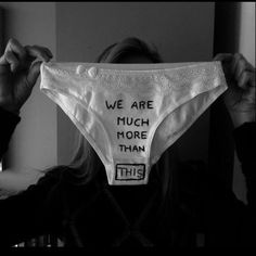 a woman holding up a cloth with words on it that say we are much more than