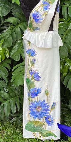 a white dress with blue flowers painted on it