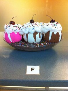 three desserts are sitting on a plate with sprinkles and frosting