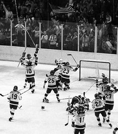 the hockey players are celebrating their goal in front of an ice rink full of people