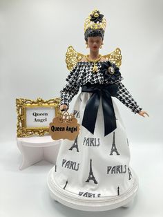 a doll is dressed in a dress with the words queen angel and paris on it