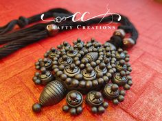 a bunch of beads that are sitting on a red tablecloth with the words crafty creations written above it