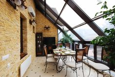 an outdoor dining area with tables and chairs under a glass roof over looking the water