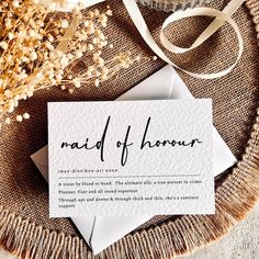 a piece of paper with the word maid of honor on it next to some flowers