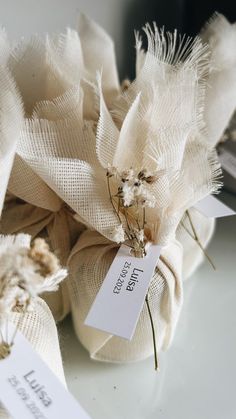 dried flowers are wrapped in burlocks on a white tablecloth with price tags