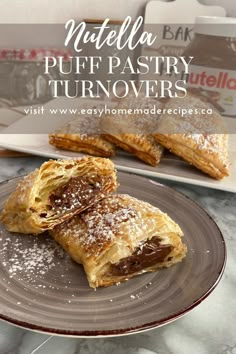 nutella puff pastry turnoverers on a plate with powdered sugar and chocolate filling