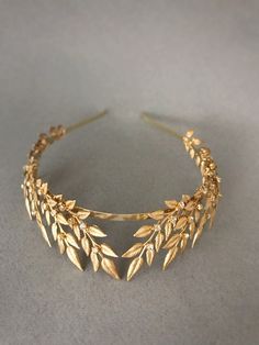 a close up of a gold headband with leaves on it's side,