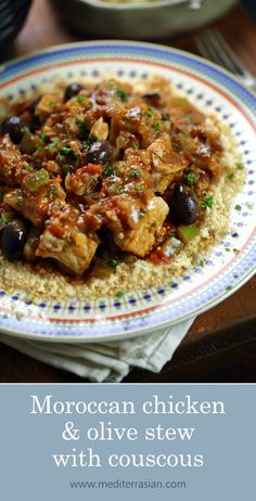 moroccan chicken and olive stew with couscous in a blue and white plate on a wooden table