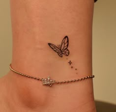 a small tattoo on the ankle of a woman's foot with a butterfly and stars