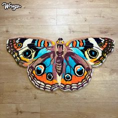 a butterfly shaped rug on the floor with an image of a blue and orange butterfly